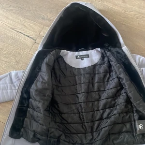 Grå jacka från moose knuckles  - Säljer en stilren grå jacka från Represent med huva och dragkedja. Jackan har en quiltad insida och en snygg detalj på ärmen. Perfekt för vilken dag som helst