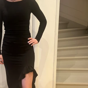 Svart långklänning från Gina Tricot - Elegant svart långklänning från Gina Tricot med långa ärmar och en stilren slits. Perfekt för en kväll ute eller en speciell tillställning. Klänningen har en figurnära passform som framhäver silhuetten. (Nypris 600) Passar både xs och s. Är i nyskick, har endast använts en gång. Fråga för mer bilder eller andra funderingar!💗