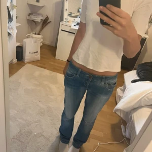 jeans lågmidjade med slitningar - bootcut/straight jeans med slitningar. fina ljusblå och är 36 i midjan o 79 i längd💓