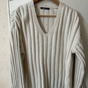 Vit ribbad tröja från Gina Tricot - Säljer en stilren vit ribbad tröja från Gina Tricot. Tröjan har en v-ringad hals och långa ärmar, perfekt för kyligare dagar. Den är både bekväm och trendig, ett måste i garderoben! 🖤