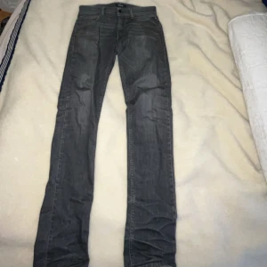 Grå jeans från Replay - Snygga grå jeans från Replay med en klassisk femficksdesign. De har en knappgylf och är tillverkade i ett slitstarkt material. Perfekta för en stilren look.
