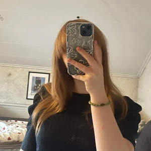 Marinblå Topp med puff armar - Snygg marinblå topp med spetsdetaljer som ger en elegant touch. Toppen har korta ärmar och en bekväm passform.