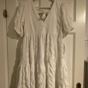 Vit klänning med knyt i ryggen - Fin vit klänning med knytning i ryggen 💕Säljer då den inte kommer till användning. Fint skick, använd endast en gång. Nypris 599kr 