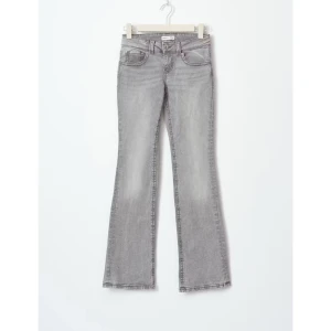 Grå low waist bootcut jeans - Snygga grå bootcut jeans med knappar därbak . Low waist,är 162 och passar parfekt i längden