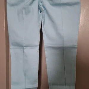 Ljusblå byxor - Snygga ljusblå byxor med en rak passform. Perfekta för en stilren look. Byxorna har en enkel design utan synliga detaljer.