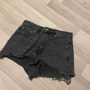 Svarta jeansshorts med fransar - Snygga svarta jeansshorts med fransiga kanter. Ger en cool look.