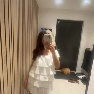 Vit vila g klänning ifrån Anielle label  - En jätte fin hand sydd vit volang klänning ifrån Anielle label, i ny skick, endast använd en gång. Ny pris 1 395 kr