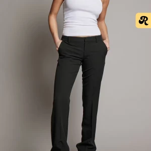 Svarta kostymbyxor - Snygga svarta kostymbyxor med en klassisk design. De har en normal passform och är perfekta för en stilren look. Byxorna har en dragkedja och knappar framtill.