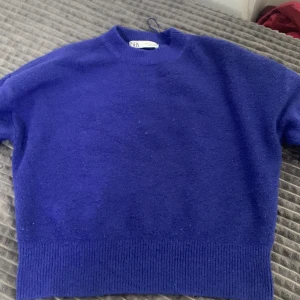 Blå stickad tröja från Zara - Säljer en snygg blå stickad tröja från Zara. Tröjan har en klassisk rund halsringning och långa ärmar. Perfekt för kyligare dagar och ger en stilren look. Passar bra till både jeans och kjol. 🌀