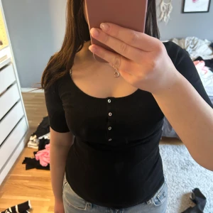 Tshirt  - Svart ribbad tshirt med knappar.