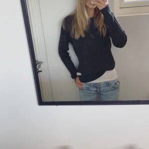 Mörkgrå stickad tröja från Odd Molly - Säljer en snygg mörkgrå stickad tröja från Odd Molly. Tröjan har ett klassiskt flätmönster och långa ärmar med ribbade muddar. Perfekt för kyligare dagar. Passar bra till jeans eller kjol för en avslappnad look.