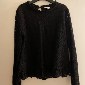 Svart spetsblus från Vila - Fin svart spetsblus från Vila med långa ärmar och volangdetaljer vid hals och nederkant. Den är i storlek 34 i fint skick.🖤Säljs för 150kr men priset kan diskuteras.
