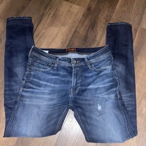 Mörkblå jeans från Jack & Jones - Snygga mörkblå jeans från Jack & Jones med en klassisk femficksdesign. De har en normal passform och är tillverkade i slitstarkt denim. Perfekta för en avslappnad stil.