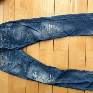 Blå jeans med slitningar Dondup - Blå jeans från dondup med slitningar, ett hål i knät som syns på bild, storlek 34