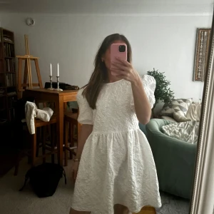 Vit klänning med puffärmar från BYIC - Charmig vit klänning från BYIC med puffiga ärmar. Perfekt till studenten eller midsommar. Prislappen är ej kvar men klänningen är endast testad. 