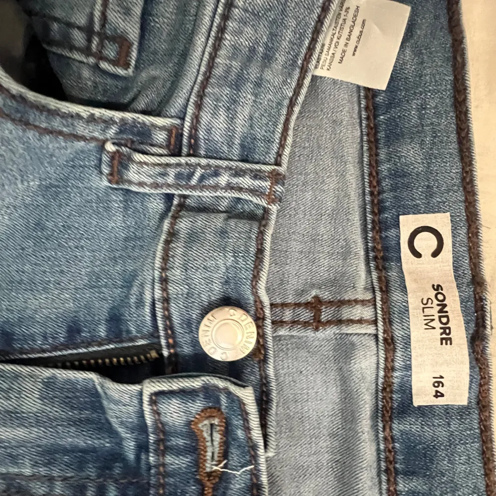 Snygga blå slim jeans från Cubus i en klassisk denimstil. De har en dragkedja och knapp framtill samt hällor för bälte. Perfekta för en stilren look.. Farkut & Housut.