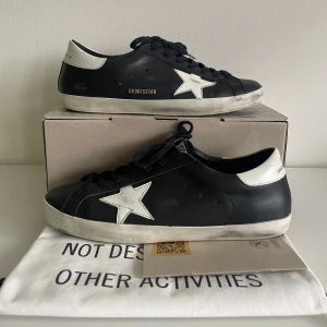 Golden goose skor - Säljer ett par sjukt snygga golden goose skor i storleken 45. De är i ett bra skick förutom att de har små sprickor i sulan runtom skon (bild 5), varav en är lite större (bild 4). Med skorna får man lådan, en påse o ett certifikat. Skriv vid funderingar!