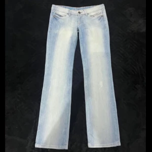 Lågmidjade utsvängda jeans  - Supersnygga ljusblå lågmidjade jeans från Diesel med nitar vid fickorna, se alla mått på bilderna!