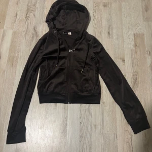 Svart hoodie med dragkedja från Gina tricot - Snygg svart hoodie med dragkedja och huva. Den har långa ärmar och ribbade muddar. Perfekt för en avslappnad stil.