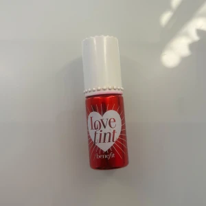 Röd Love Tint från Benefit - Säljer en röd Love Tint från Benefit. Denna läpp- och kindfärg kommer i en liten flaska med vit kork och pärldetaljer. Perfekt för att ge en naturlig rodnad eller färg till läpparna. Den är använd några gånger💕
