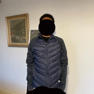 Mörkblå quiltad jacka från 157 - Säljer en mörkblå quiltad jacka från 157. Jackan har en dragkedja framtill och långa ärmar. Perfekt för kyligare dagar med sin stilrena design och bekväma passform.