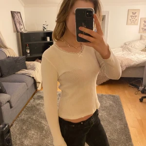 Vit tröja med spetsdetalj - Säljer en vit ribbad tröja från Brandy Melville med spetsdetaljer vid halsringningen. Säljer den för den inte längre kommer till användning❤️