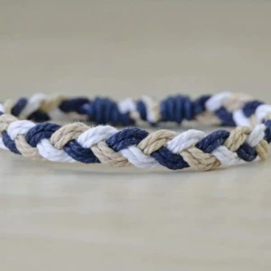 Flätat armband i beige och blått - Snyggt flätat armband i beige och blått. Perfekt accessoar för en avslappnad stil. Justerbar storlek med knytband för att passa de flesta handleder.