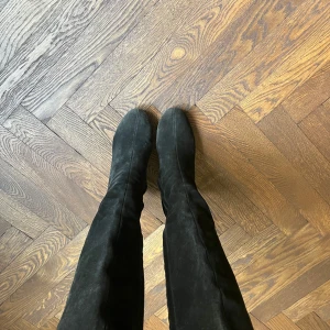 Svarta mockastövlar med dragkedja - Snygga svarta stövlar i mocka med dragkedja på sidan. Perfekta för en stilren look och passar bra till både jeans och klänning. De har en spetsig tå och en elegant design.