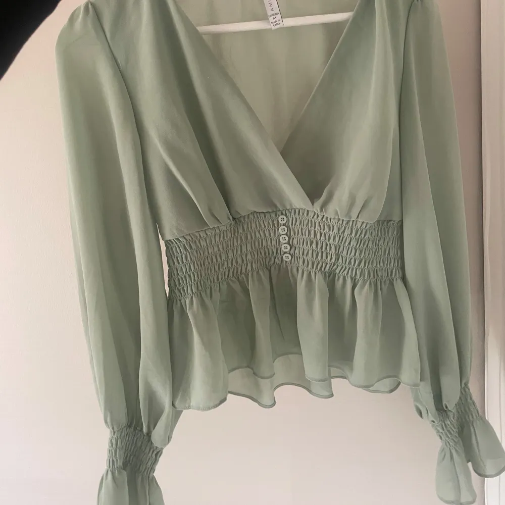 Super fin blus som är figursydd och volanger vid ärmarna de är storlek M men som en S . Puserot.