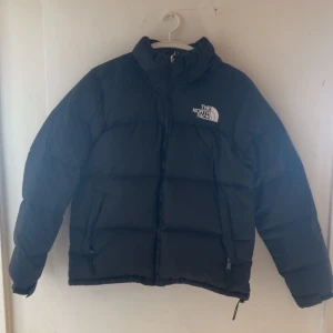 The North Face Nuptse 1996 Jacka Herr - Säljer denna North Face jacka till ett väldigt billigt pris eftersom jag har köpt en ny likadan, Jackan är helt felfri förutom att den har behövts lagas på ryggen samt vänster arm men dessa märken syns knappt vid användning. Jackan är i small men den satt perfekt på mig som är 180 cm lång. Hör av dig vid intresse 💫 Ny pris brukar variera mellan 3000kr - 4000kr 