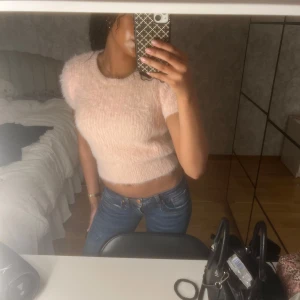Rosa fluffig croppad topp - Säljer en supermjuk och fluffig rosa croppad topp med korta ärmar. Toppen har en härlig textur som ger en extra touch till din outfit. Storlek M men sitter som en S eller XS