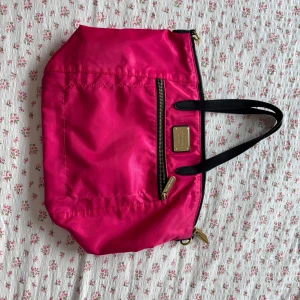 Rosa leopard axelväska från Victoria's Secret - Snygg rosa axelväska från Victoria's Secret med leopardmönstrat foder. Väskan har en praktisk dragkedja och svarta handtag. Perfekt för att ge en färgklick till din outfit!