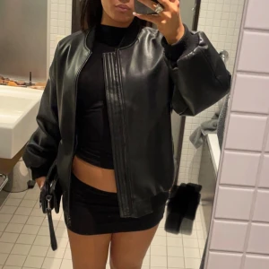 Svart skinnjacka - INTRESSEKOLL! Från bikbok storlek S som inte går att köpa längre. Köpt för 900kr. Snygg svart skinnjacka med dragkedja framtill. Jackan har en oversized passform och långa ärmar, perfekt för en cool och avslappnad stil.