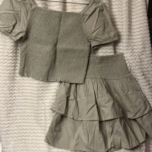 Grön topp och kjol från Kappahl. 💚 - Säljer ett sätt med en söt grön topp och en fin kjol från Kappahl med smockdetaljer och korta puffärmar. Som ny jag har bara tagit av lappen.  🍀🍀