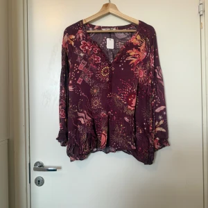 Odd molly blus  - Säljer en superfin vinröd blus med detaljer i gul, rosa och orange. Från märket Odd Molly i storlek 2 som enligt deras storleksguide motsvarar en storlek M. Mycket fint skick, jag hittar inga synlig anmärkningar eller defekter.  