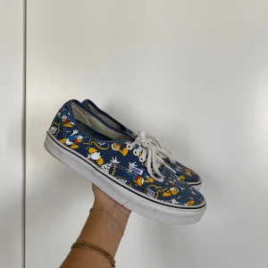 Vans - Skor från Vans med Kalle Anka-mönster på, herr. Något slitna baktill i hälen (se bild) men annars OK skick!