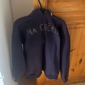 Ma cherie hoodie med luva  - Marinblå tröja med motivet ma cherie i silver stenar. Säljs ej i butik längre har ett par tvätt fläckar i back av tröjan. Super bekväm och perfekt för vintern köpt för 200 spänn