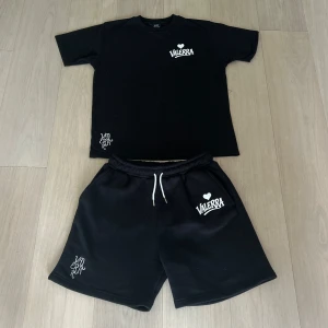 Valerra summer set - sommarset från Valerra, bestående av matchande T-shirt och shorts. Setet har en minimalistisk design med en broderad logga på bröstet och en större tryckt logga som ger en modern touch.  Materialet är av premiumkvalitet – huvudsakligen bomull – vilket gör det både bekvämt och perfekt för varma dagar. Det här setet är en del av en exklusiv drop och kommer med största sannolikhet inte att släppas igen i år.  Perfekt för dig som gillar stilrena, street-inspirerade plagg med hög kvalité!