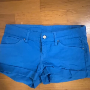 Blå jeansshorts från Mango Jeans - Snygga blå jeansshorts från Mango Jeans , färgglada shorts som e lowwaist o sitter väldigt fint , gott skick 