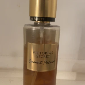 Victoria's Secret Coconut Passion - Fräsch body mist från Victoria's Secret i doften Coconut Passion. Flaskan är genomskinlig med guldigt lock och etikett. Doften har tropiska toner av kokos och vanilj, perfekt för dig som gillar söta och exotiska parfymer.