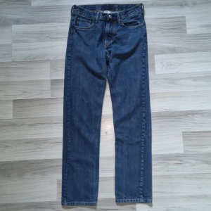 Mörkblå jeans från H&M &Denim - Klassiska mörkblå jeans från H&M &Denim med raka ben och femficksdesign. Jeansen har normal passform, bälteshällor och snygga kontrastsömmar. Perfekta för dig som gillar enkel och tidlös stil.