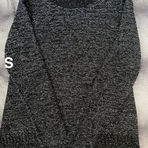 Mörkgrå stickad tröja i storlek S - Mysig mörkgrå stickad tröja i melerad look. Tröjan har rund halsringning och långa ärmar, perfekt för lager-på-lager under kyliga dagar. Passar dig som gillar en enkel och stilren vibe.🌸Fint använt skick. Silvertråd. Storlek s 