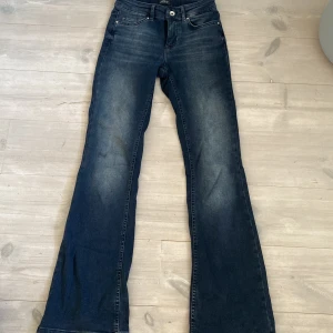 Mörkblå bootcut jeans från ONLY XS - Snygga mörkblå jeans från ONLY i bootcut-modell. Jeansen har klassisk femficksdesign & lätt slitna detaljer framtill. Tillverkade i mjukt denimtyg som sitter skönt och ger en cool siluett.