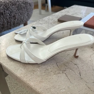 Vita sandaler/ klackar från mango - Vita sandaler från Mango. Klacken är ca 5 cm. De är aldrig använda och skickas i original box❤️Hör av er om ni har några frågor🥰