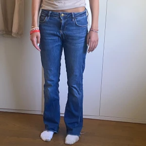 Blå utsvängda jeans - Säljer ett par supersköna jeans från Zara💕 Jag har klippt av några cm längst ner på benen eftersom de var för långa💕Jag är 1,65 på bilden
