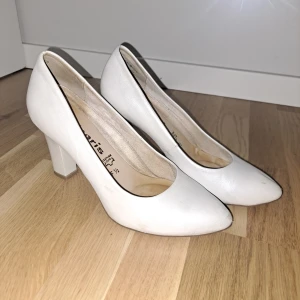 Vita pumps från Tamaris i skinn - Klassiska vita pumps från Tamaris i äkta skinn. Skorna har spetsig tå och stabil, bred klack som ger en snygg siluett. Perfekta för dig som gillar stilrena och tidlösa skor med en feminin touch. Sköna att gå i, säljer för dem nu är försmå.🥰 pris går alltid att diskutera.
