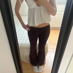 Mörkröda/lila manchesterbyxor bootcut - Säljer ett par mörkbruna manchesterbyxor med bootcut och låg midja. Byxorna har klassisk femficksdesign och är i ett mjukt, stretchigt manchestertyg. Säljer då jag är väldigt lång och dem är för korta. S-M