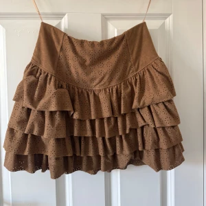 Brun volangkjol med broderade detaljer - Supersöt brun kortkjol med broderade hål! Super snygg till sommaren!