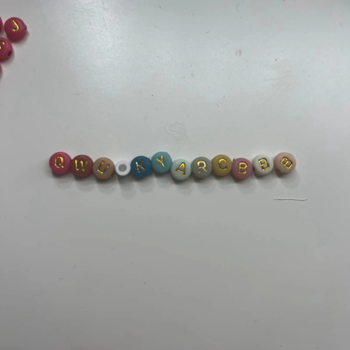 Färgglada bokstavspärlor i ask