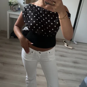 Svart prickig offshoulder topp - Säljer en svart offshoulder topp med vita prickar och croppad passform. Toppen har bred resår i midjan som ger en snygg siluett och är ärmlös. Köpte här på plick men känner ej att den passar mig som jag vill😍, design by si liknande 😍😍😍